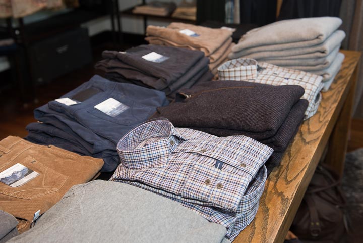 Table filled with men's shirts and sweaters